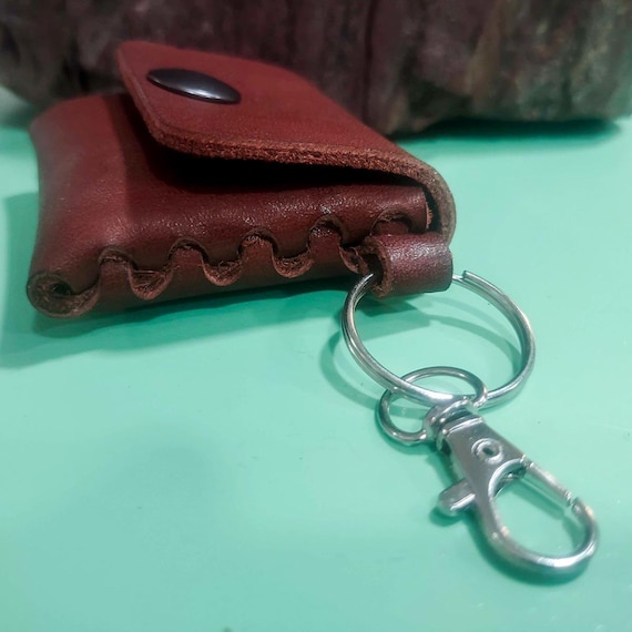 A tiny handmade leather pouch keychain in saddle brown Latigo buffalo — it's a mini coin purse AND a keychain, made in a limited run from serious leather stock.