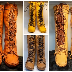 May include: Three pairs of tall, brown leather boots with laces. The boots are knee-high and have a moccasin-style toe. The laces are tied in a bow at the top of the boots. The boots are in different shades of brown.