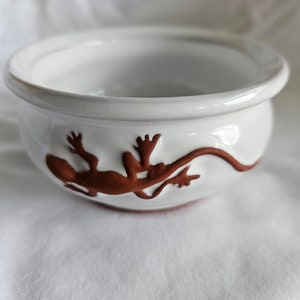 May include: A set of three ceramic mugs with a speckled, matte finish. The mugs are in shades of cream, light gray, and dark gray. Each mug has a simple, modern design and a rounded handle. The mugs are stacked on top of each other.