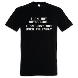 Op de afbeelding: Zwart T-shirt met witte tekst: "I AM NOT ANTISOCIAL I AM JUST NOT USER FRIENDLY." Het shirt heeft korte mouwen en een ronde hals. De tekst staat in het midden van de voorkant.