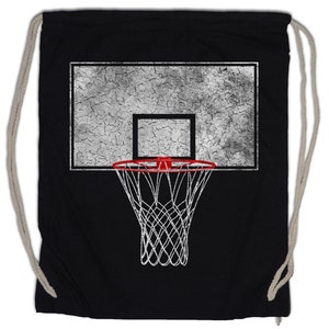 Könnte beinhalten: Schwarzer Turnbeutel mit Basketballkorb-Design. Das Design umfasst ein strukturiertes, abgenutztes Backboard, einen roten Ring und ein weißes Netz. Die Tasche hat beige Kordelzüge.