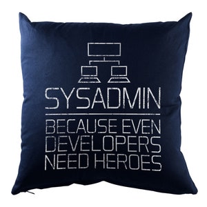 Pode incluir: Uma almofada azul marinho com texto branco que diz "SYSADMIN porque até os desenvolvedores precisam de heróis". O texto é estilizado para parecer um diagrama de rede de computadores.