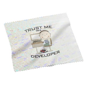 Könnte beinhalten: Ein weißes Mikrofaser-Reinigungstuch mit einem bunten, pixeligen Hintergrund. Das Tuch zeigt eine Cartoon-Illustration einer Person, die an einem Computer sitzt, mit dem Text "Trust Me I'm A Developer".