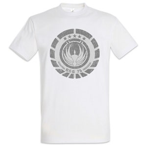 Könnte beinhalten: Weißes T-Shirt mit einem grauen, abgenutzten Aufdruck des Battlestar Galactica-Logos. Das Logo zeigt einen stilisierten Vogel mit ausgebreiteten Flügeln und dem Text "BSG 75".