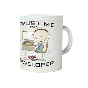 Puede incluir: Taza de cerámica blanca con una ilustración de dibujos animados de una persona frente a un ordenador. La taza tiene el texto "TRUST ME I'M A DEVELOPER" impreso. El fondo tiene un patrón de código claro.