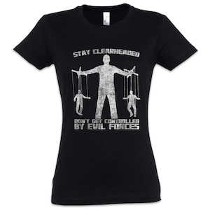 Peut inclure: T-shirt noir avec un motif blanc vieilli représentant un marionnettiste contrôlant deux marionnettes. Le texte indique "STAY CLEARHEADED" et "DON'T GET CONTROLLED BY EVIL FORCES".