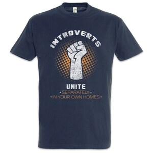 Può includere: Una maglietta blu navy con una grafica bianca usurata di un pugno con il testo "Introversi Unitevi Separatamente Nelle Vostre Case".