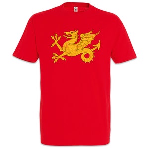 Peut inclure: T-shirt rouge avec un emblème de dragon doré vieilli. Le dragon, aux ailes déployées, est centré sur le vêtement. Le t-shirt a des manches courtes et un col rond.