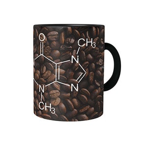 Puede incluir: Taza de café negra con una fórmula química blanca y un patrón de granos de café marrones. La fórmula incluye el texto "CH3" y "N".