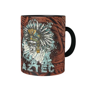 Könnte beinhalten: Eine schwarze Keramiktasse mit einem braunen und weißen Design, das eine indianische Kopfbedeckung und das Wort "Aztec" zeigt.