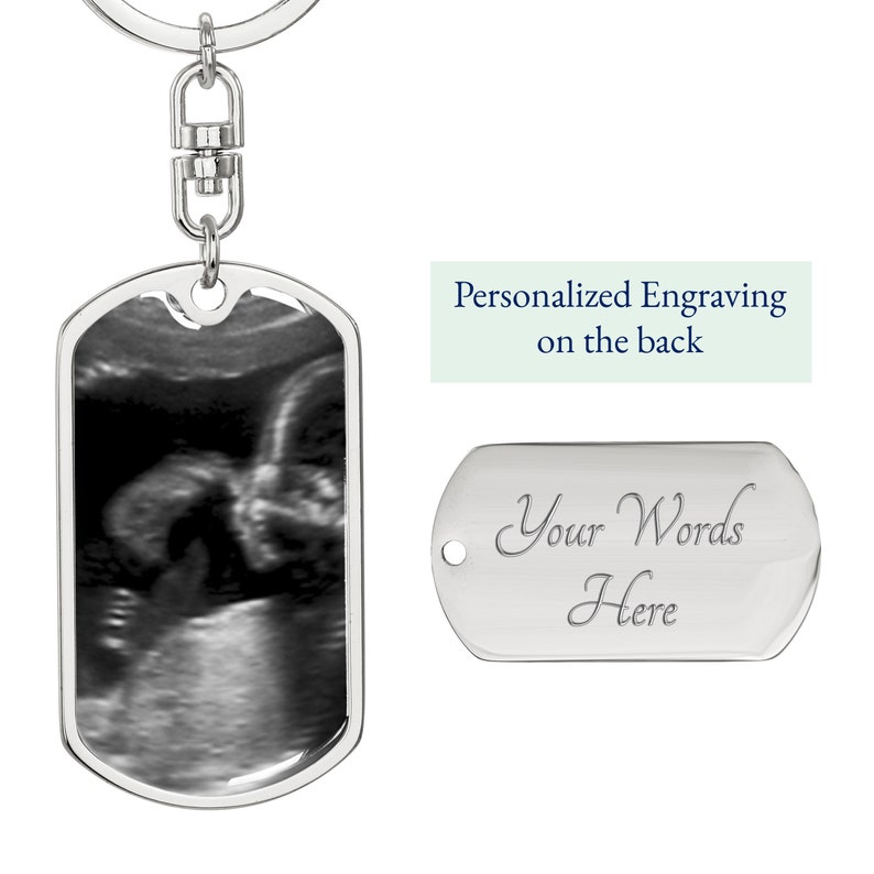 Pu&ograve; includere: Portachiavi in ​​argento con un'immagine di ecografia in bianco e nero sul davanti e un'etichetta in argento vuota sul retro che dice "Le tue parole qui".