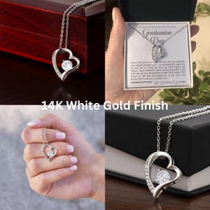 Peut inclure: Un collier pendentif en forme de c&oelig;ur avec une finition en or blanc et un cristal transparent. Le collier est pr&eacute;sent&eacute; dans un coffret cadeau avec le texte "To our granddaughter on your Graduation Day."