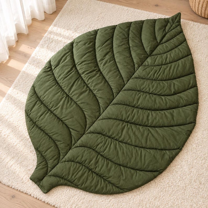 Leaf shaped cotton baby play mat in neutral beige on a nursery floor