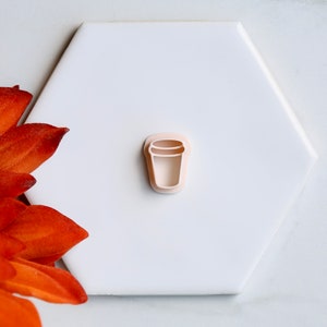 以下が含まれることがあります： コーヒーカップの形をした白いプラスチック製のクッキーカッターです。