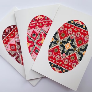 May include: Three white cards with red, green, and yellow patterned Easter eggs. The eggs are in the shape of a heart, oval, and circle.