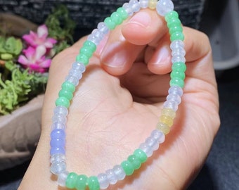May include: A jade bracelet with green, white, and yellow beads. The bracelet is made of small, round beads that are strung together.