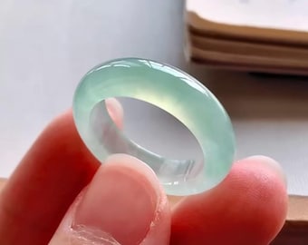 May include: A light green jade ring with a smooth, polished surface.