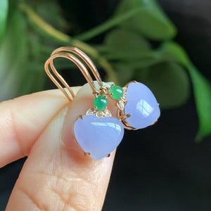 May include: A pair of heart-shaped lavender jade earrings with green jade accents and diamond accents set in gold.