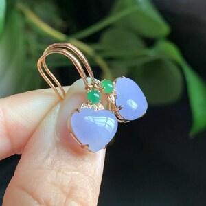 May include: A pair of heart-shaped lavender jade earrings with green jade accents and gold settings.