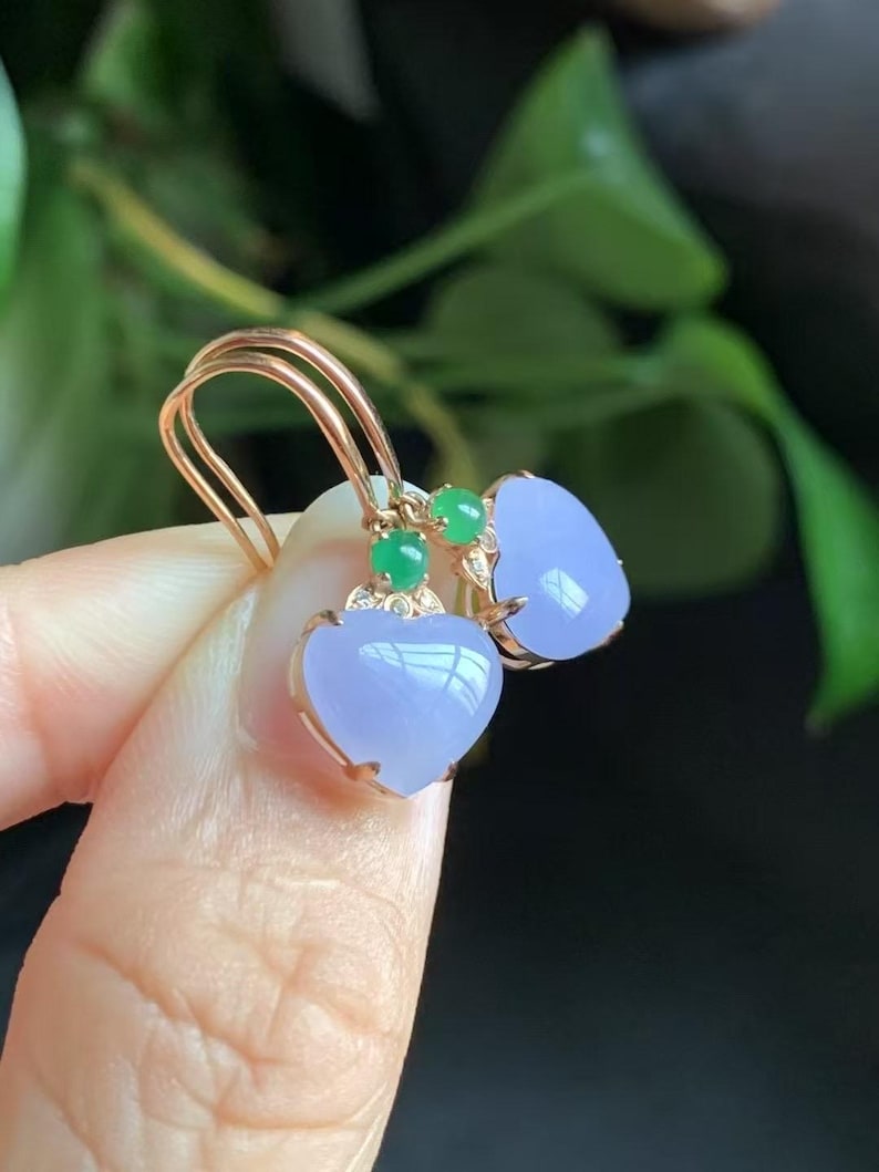 May include: A pair of heart-shaped lavender jade earrings with green jade accents and gold settings.