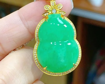 May include: A green jade pendant in the shape of a gourd, set in a gold frame with small diamonds. The pendant is attached to a gold chain.