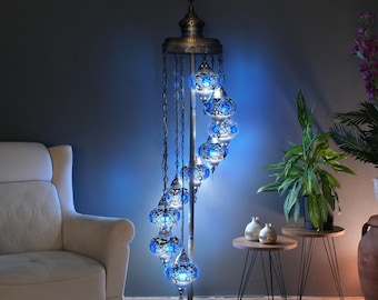 May include: A spiral floor lamp with a brushed metal base and blue mosaic glass globes. The lamp is lit and casts a blue glow.