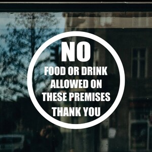 May include: White circular sticker with the text "NO FOOD OR DRINK ALLOWED ON THESE PREMISES THANK YOU" on a glass door.