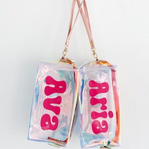 May include: Two iridescent clear cosmetic bags with pink straps and pink "Baby" lettering.
