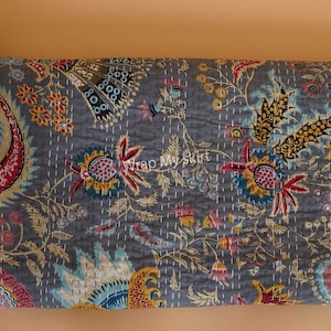May include: A gray kantha quilt with a floral pattern in shades of red, yellow, blue, and green. The quilt is hand-stitched and has a traditional Indian design.
