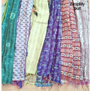 May include: A collection of seven colourful kantha quilts with various patterns and designs. The quilts are made from recycled saris and are perfect for adding a touch of bohemian style to any home.