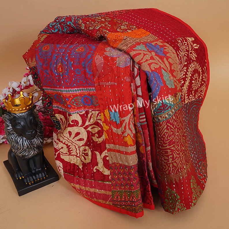 Pu&ograve; includere: Una trapunta kantha rossa e multicolore con un motivo floreale. La trapunta &egrave; realizzata con sari riciclati ed &egrave; cucita a mano. "Wrap My Skirt" &egrave; stampato sulla trapunta.