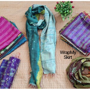 May include: Assortment of colorful kantha stitch scarves in various patterns and colors, including teal, blue, purple, pink, and green. The scarves are made of recycled saris and are perfect for adding a touch of bohemian style to any outfit.  WrapMySkirt.