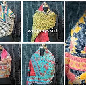 Op de afbeelding: Zes verschillende kantha-dekens, elk met een uniek patroon en kleurenschema. De dekens zijn gemaakt van gerecyclede sari's en zijn met de hand gestikt. De dekens worden getoond op mannequins en zijn gevouwen in een driehoekige vorm.