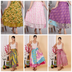 May include: A collection of colorful wrap skirts in various floral and patterned designs. The skirts feature a layered construction with different fabric patterns and colors, including green, pink, purple, blue, and yellow. Each skirt is tied at the waist.