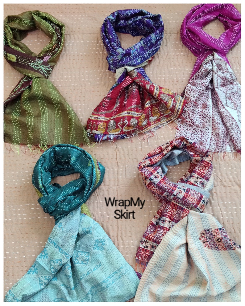 May include: Five colourful silk scarves with different patterns and colours. The scarves are folded and arranged on a light brown background. The text "WrapMy Skirt" is visible in the centre of the image.