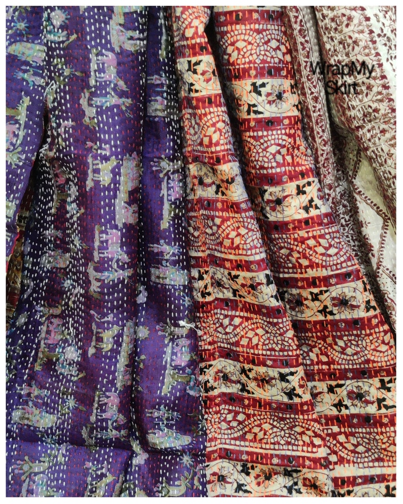 May include: A multi-colored kantha quilt with a purple, red, and white pattern. The quilt is made of cotton and has a hand-stitched design. The quilt is a traditional Indian textile.
