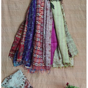 May include: A stack of colorful kantha quilts with a variety of patterns and textures. The quilts are made of recycled saris and are perfect for adding a touch of bohemian style to any home.
