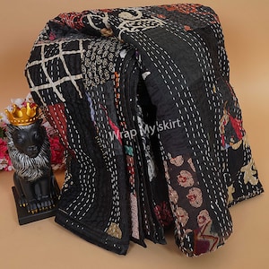 Puede incluir: Colcha kantha negra con un dise&ntilde;o de patchwork que presenta varios colores y patrones. La colcha est&aacute; cosida a mano y tiene un borde deshilachado. El texto "Wrap My Skirt" es visible en la colcha.