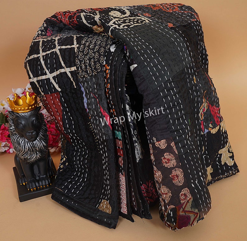 Puede incluir: Colcha kantha negra con un dise&ntilde;o de patchwork que presenta varios colores y patrones. La colcha est&aacute; cosida a mano y tiene un borde deshilachado. El texto "Wrap My Skirt" es visible en la colcha.