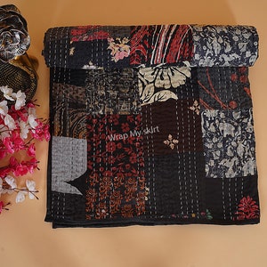 May include: Black and white kantha quilt with a patchwork design featuring floral and geometric patterns. The quilt is made of cotton and has a hand-stitched look.