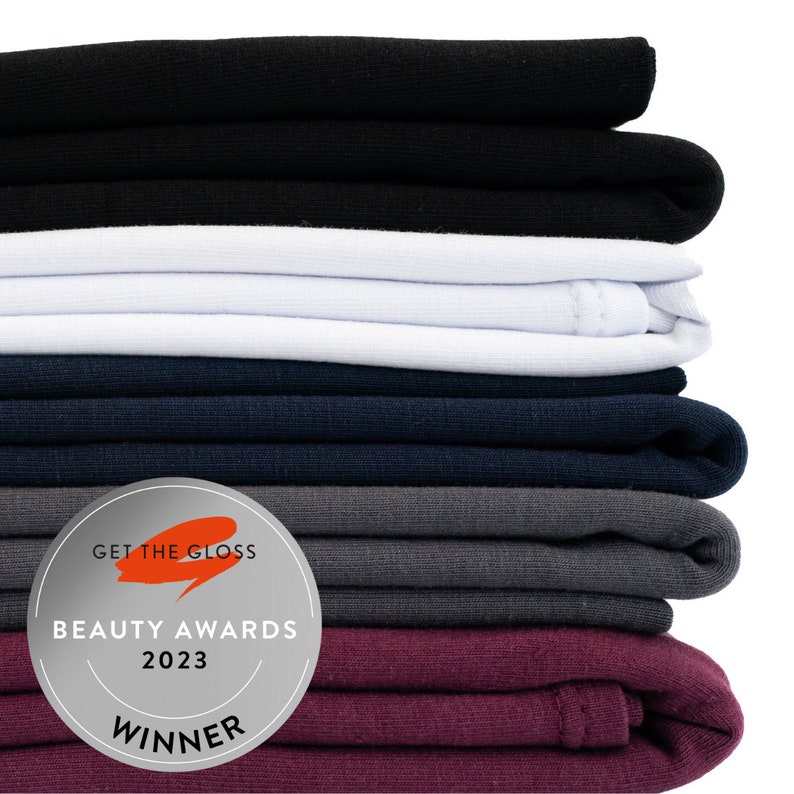 Stack of folded good wash day hair towels in neutral colours with get the glass beauty awards winner 2023 badge.