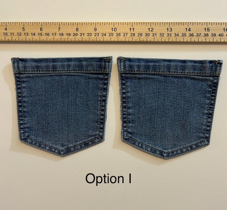 Pode incluir: Dois bolsos de ganga azul-m&eacute;dia, com uma r&eacute;gua por cima. Os bolsos t&ecirc;m formato retangular. O texto "Option I" est&aacute; em baixo.
