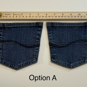 Pode incluir: Dois bolsos de ganga com uma r&eacute;gua medindo 33 cm. Os bolsos s&atilde;o azuis escuros com uma costura superior curva e formato retangular. O texto "Op&ccedil;&atilde;o A" est&aacute; abaixo dos bolsos.