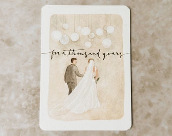 May include: Watercolor painting of a bride and groom walking down the aisle with white paper lanterns hanging above them. The text "for a thousand years" is written in cursive above the couple.