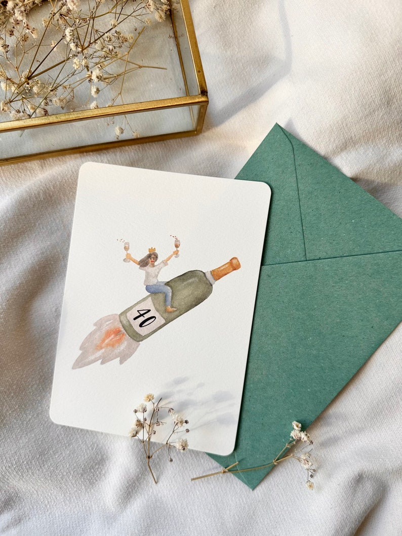 May include: A watercolor illustration of a woman wearing a crown and riding a champagne bottle shaped like a rocket with the number 40 on it. The woman is holding a glass of champagne in each hand.