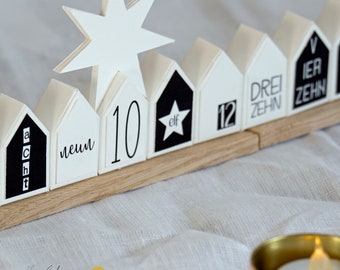 May include: A white wooden advent calendar with black numbers and text. The numbers are 1, 2, 3, 4, 5, 6, 7, 8, 9, 10, 11, 12. The text says "acht", "neun", "elf", "drei zehn", "vier zehn".