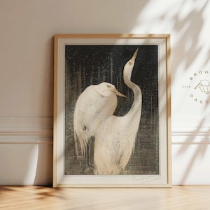 May include: A framed print of two white egrets in a black and white design. The print is titled "The Egrets" and signed by the artist "Tessa May Brown". The print is framed in a light wood frame.