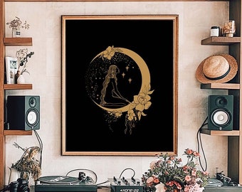 May include: A gold and black print of a woman sitting on a crescent moon with stars and flowers. The print is framed and hanging on a wall in a room with a wooden bookshelf and table.