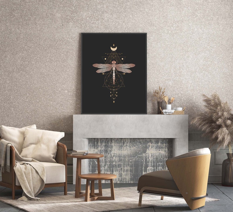 May include: A black and gold framed print with a geometric design featuring a dragonfly in the center. The dragonfly is brown and has a gold outline. The print is hanging above a fireplace.
