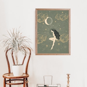 May include: A framed print with a green background and gold accents. The print features a woman with long dark hair sitting on a cloud with a crescent moon and stars in the background.